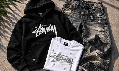 Stussy hoodie, Tenis Amiri sneakers, and Mixed Emotions rhinestone tee laid flat on a concrete surface